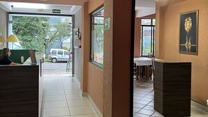 A hotel lobby with a reception desk, a dining area, and a staircase. - Vicz Palace Hotel (Curitiba)
