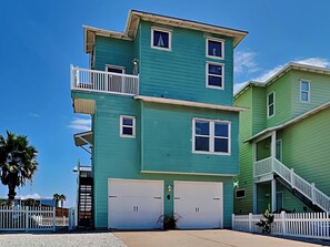 Stunning two-story home with a balcony, garage door, and charming picket fence.