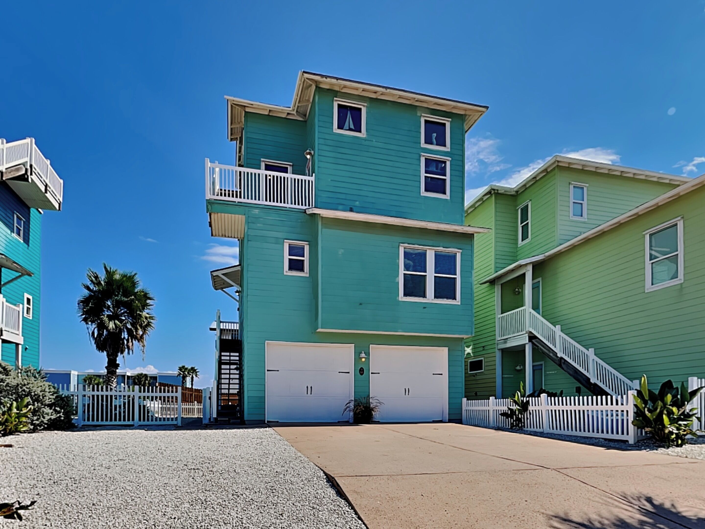 A multi-story residential building with a garage, a balcony, and a staircase.