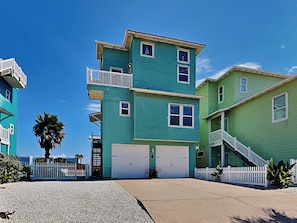 A multi-story residential building with a garage, a balcony, and a staircase. - The Fire Escape by Silver Sands Vacation Rentals (Port Aransas)