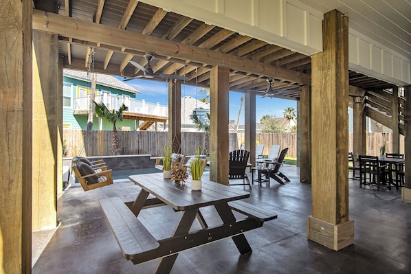 Relax in a rustic outdoor space with a wooden picnic table, Adirondack chair, and bench seating area.