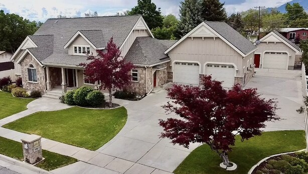 A residential house with a stone facade, a grey roof, and a well-maintained lawn. - Family FUN at the Homestead with Pool & Ping Pong, Karaoke & more! Great Value! (Brigham City)