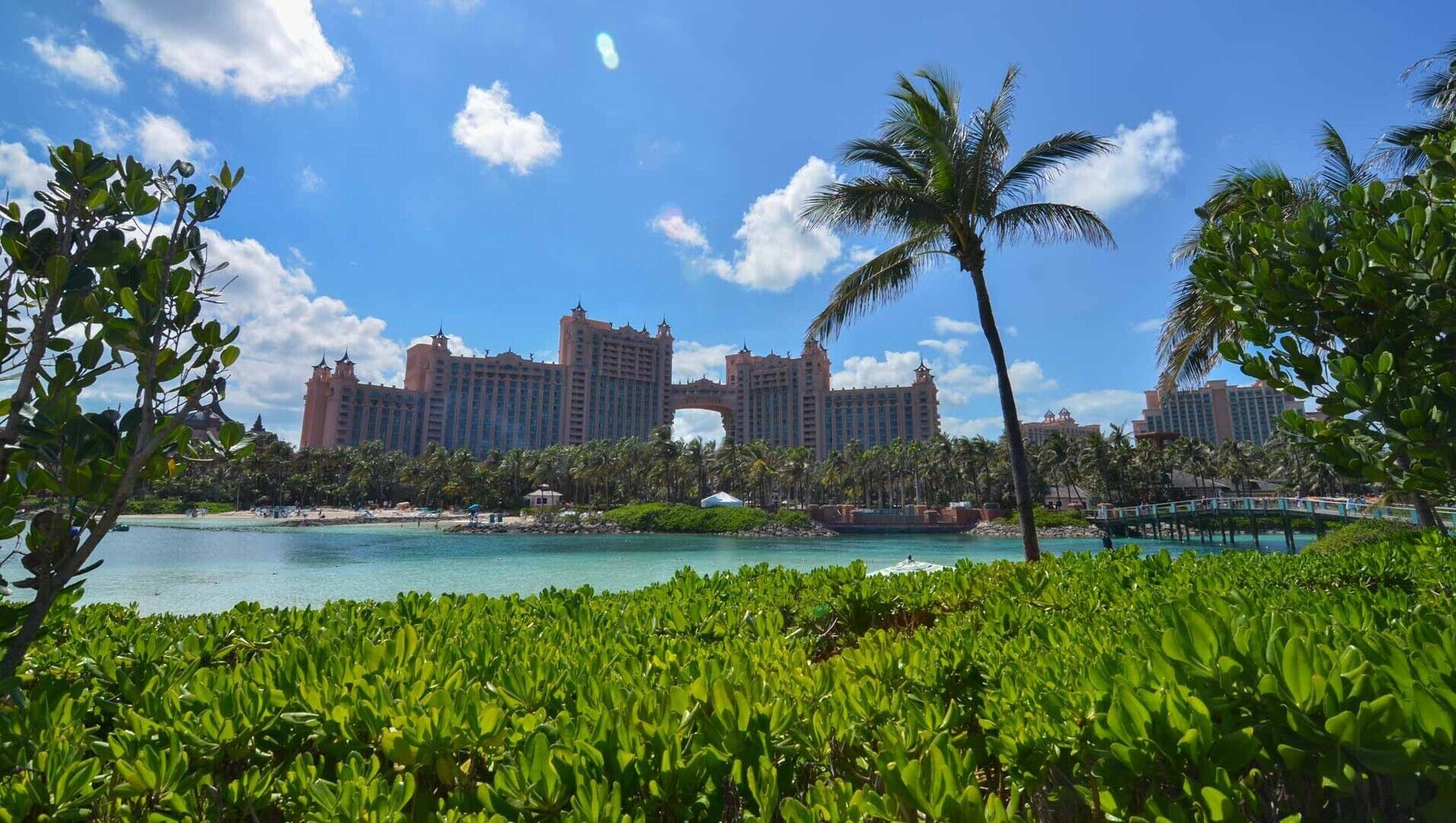 Un resort con varios edificios altos, una playa y abundante vegetación.