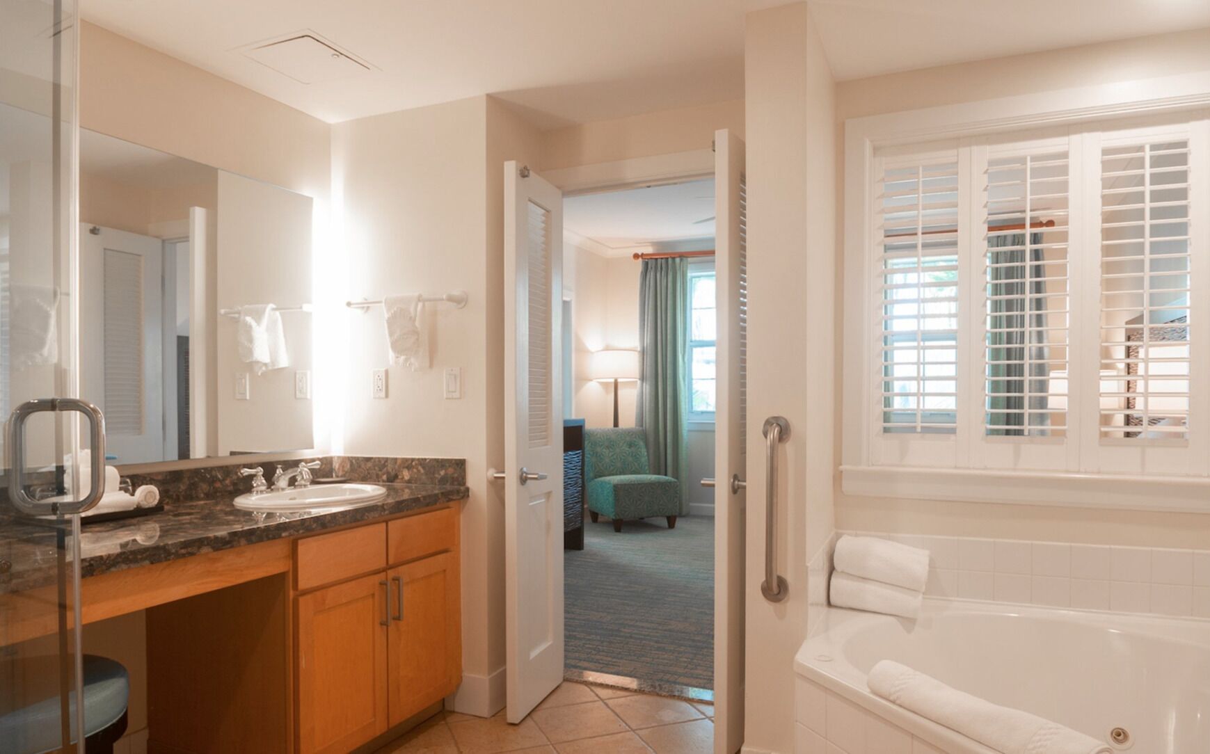 A hotel bathroom with a sink, mirror, and bathtub.
