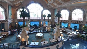 A spacious indoor area with multiple dining tables and chairs, large windows, and decorative columns. - 2 Bedroom Lock-out - Harborside Resort at Atlantis - Full Resort Access (Paradise Island)