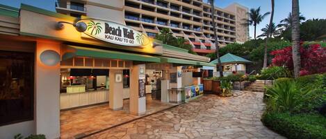 Een hotel aan het strand met een bord waarop staat 'Beach Walk Kau Kau to Go'.