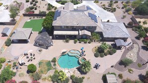 A large building with a swimming pool, outdoor seating, and solar panels.