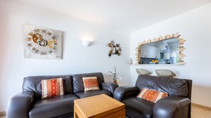 Un soggiorno moderno con un divano in pelle scura, un tavolino in legno e un elemento decorativo a parete.