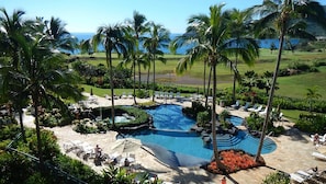 A resort with a central swimming pool, lounge areas, and palm trees. - Oceanfront - 3 Bedroom - Marriott's Kauai Lagoons - Full Resort Access (Lihue)