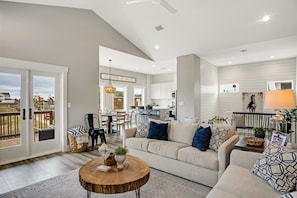 Relax in a spacious living area with a comfortable sofa set and a coffee table, adjacent to a well-equipped kitchen and dining area.