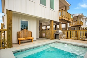 Enjoy a pool area with ocean views from the balcony, accessible via a staircase, and a barbecue grill for outdoor dining.