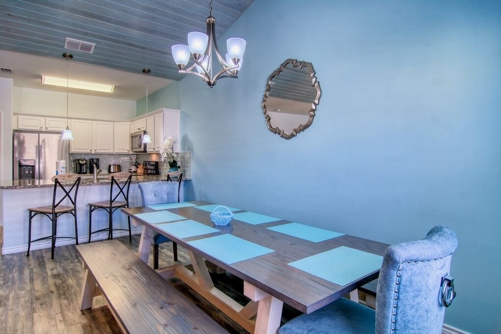 A dining area with a wooden table, chairs, and a chandelier.