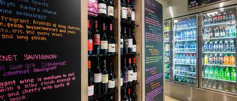 A wine and beverage display area with various bottles and a refrigerator.