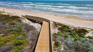 A wooden boardwalk leading to a beach with ocean views. - Beach-A-Holic by Silver Sands Vacation Rentals (Port Aransas)