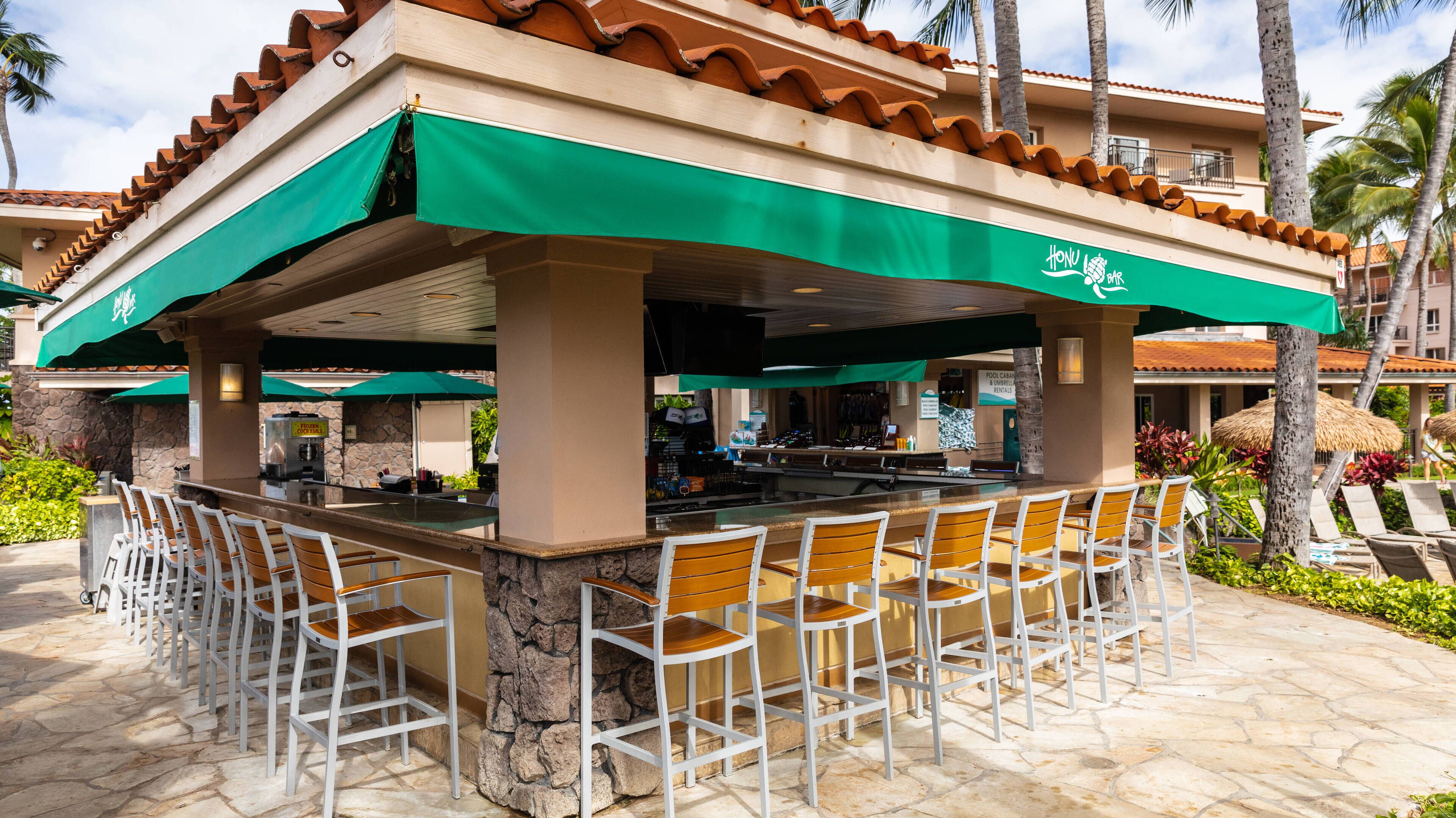 A bar area with outdoor seating and a pool sign in the background.