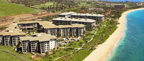 A resort with multiple buildings, a beach, and a golf course.