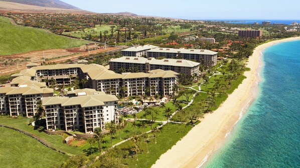 Ein Resort mit mehreren Gebäuden, einem Strand und einem Golfplatz.
