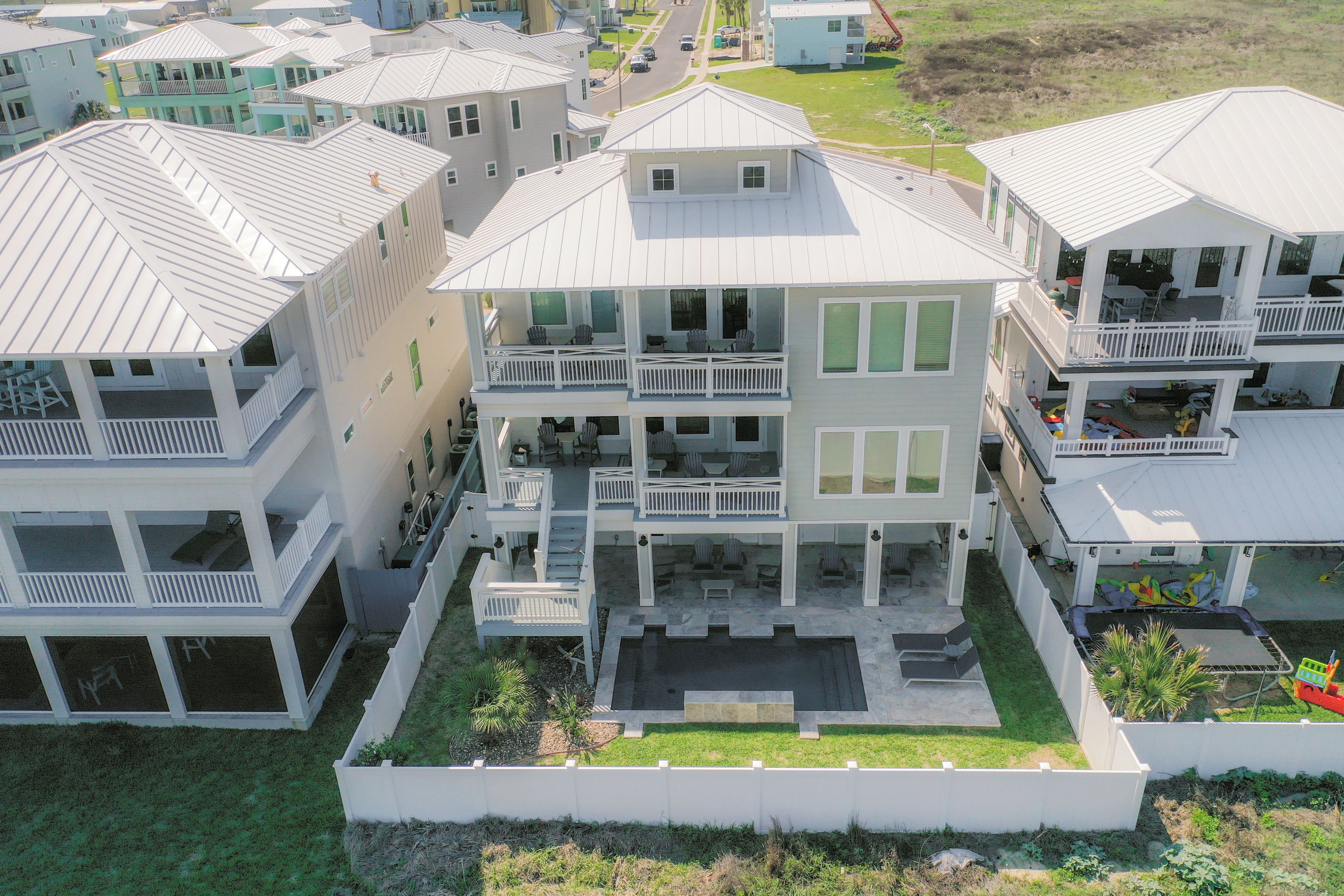 A multi-story residential building with balconies, a swimming pool, and a well-maintained lawn.