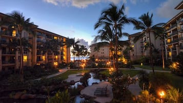 A resort with multiple-story buildings, a central courtyard with a water feature, and palm trees.