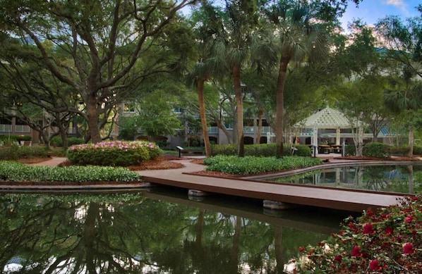 Ein angelegter Garten mit Teich, Wegen und einem Gazebo.