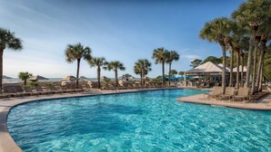 A pool area with lounge chairs and palm trees.