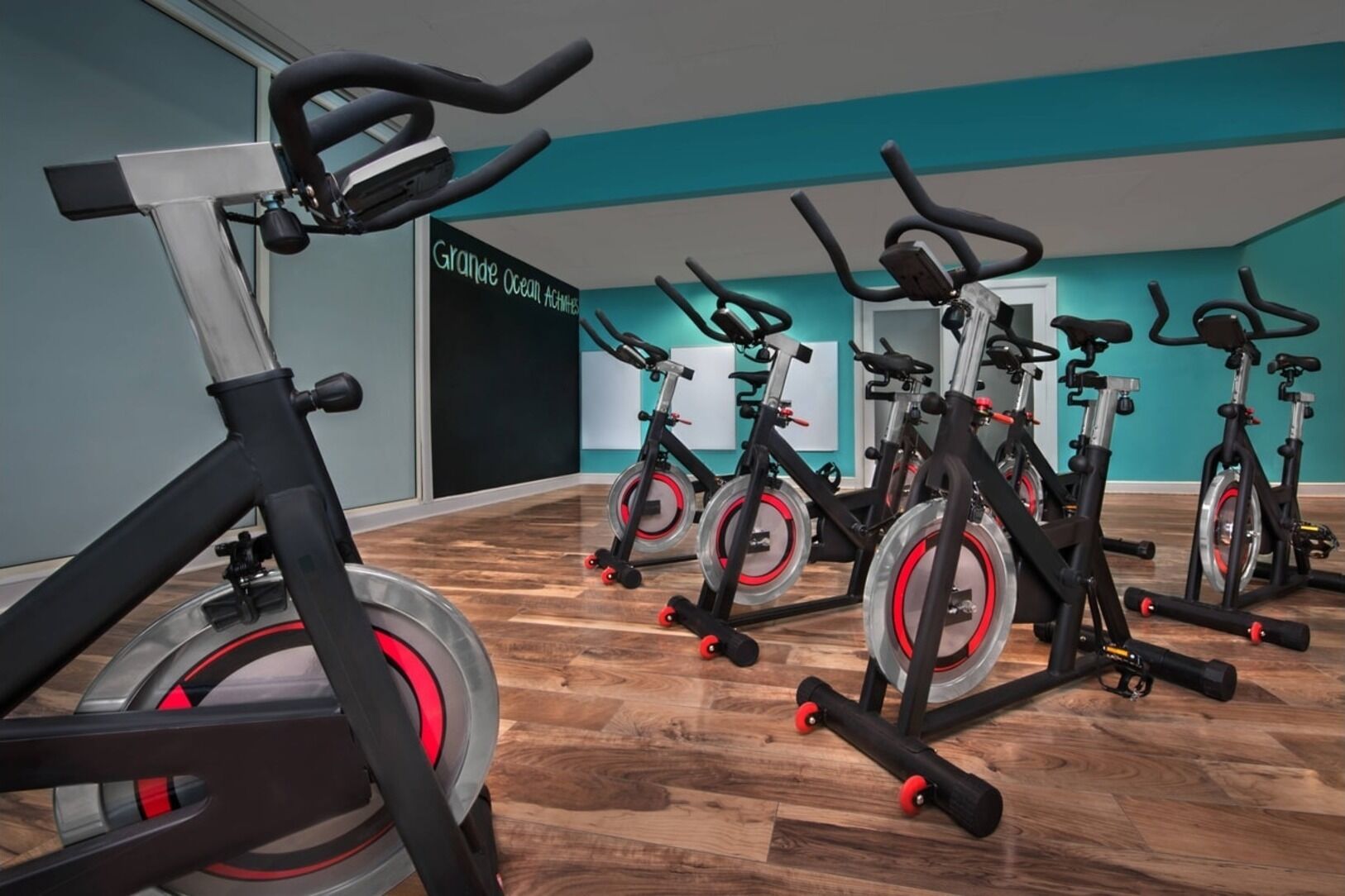 A fitness studio with stationary bikes and a wooden floor.