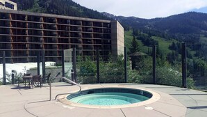 Ein Schwimmbecken mit Blick auf Berge und ein Gebäude mit Glasfassade.