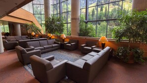 A spacious lobby with a large seating area, multiple lamps, and large windows offering a view of greenery. - Studio - The Cliff Club at Snowbird - Full Resort Access (Snowbird)