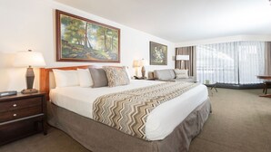 A hotel room with a large bed, a desk, a chair, a sofa, and two paintings on the walls. - Studio - The Cliff Club at Snowbird - Full Resort Access (Snowbird)