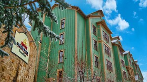 A multi-story building with a green facade and a sign for the Marriott Vacation Club.