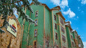 Un edificio de varios pisos con fachada verde y un letrero del Marriott Vacation Club.
