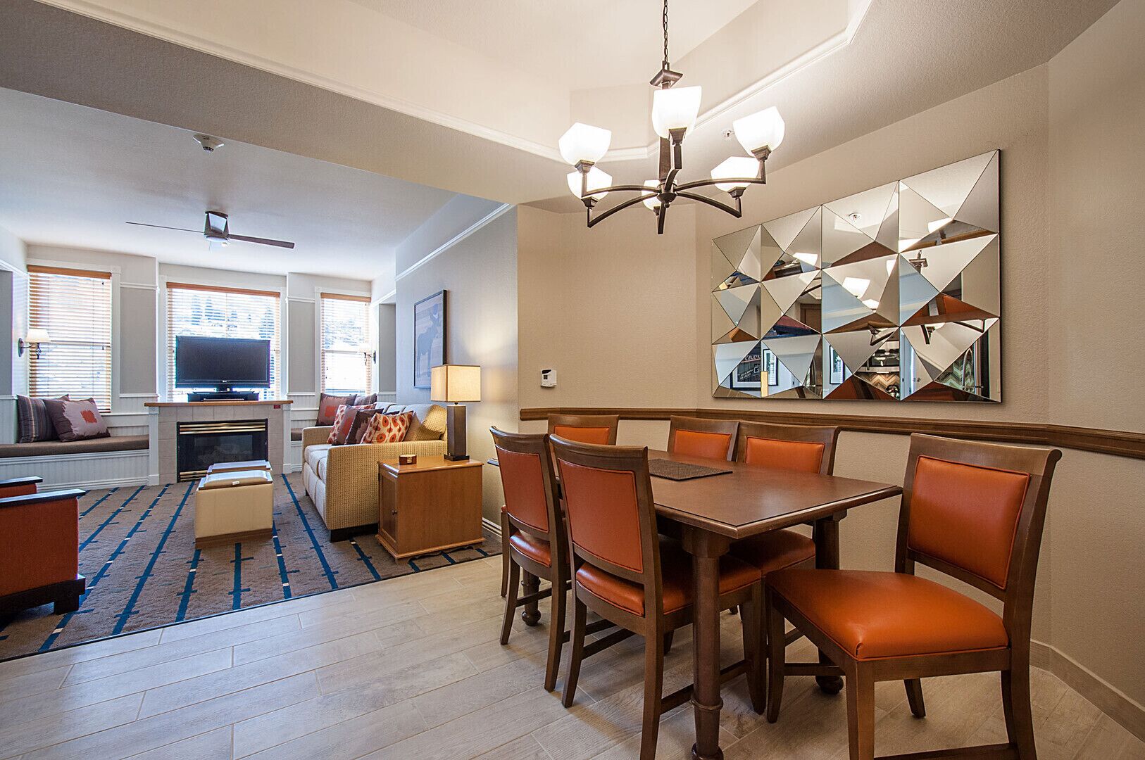 Une chambre d’hôtel comprenant un coin repas, un canapé, une télévision et une cheminée.