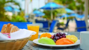 Ein Frühstückstisch mit Toast, Obst und Orangensaft.