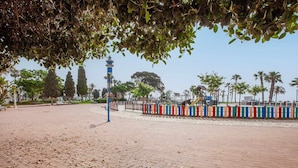 Un sendero pavimentado con una cerca, árboles y una estructura de torre.