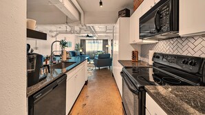 Une cuisine moderne équipée d’un four à micro-ondes, d’une cuisinière et d’un lave-vaisselle intégrés.