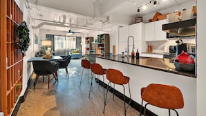 Une cuisine moderne dotée d’un coin bar, comprenant des tabourets de bar et un comptoir.