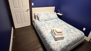 A bedroom with a bed, a nightstand, and a door. - Spacious upper-level unit located on Main St. (Vancouver)
