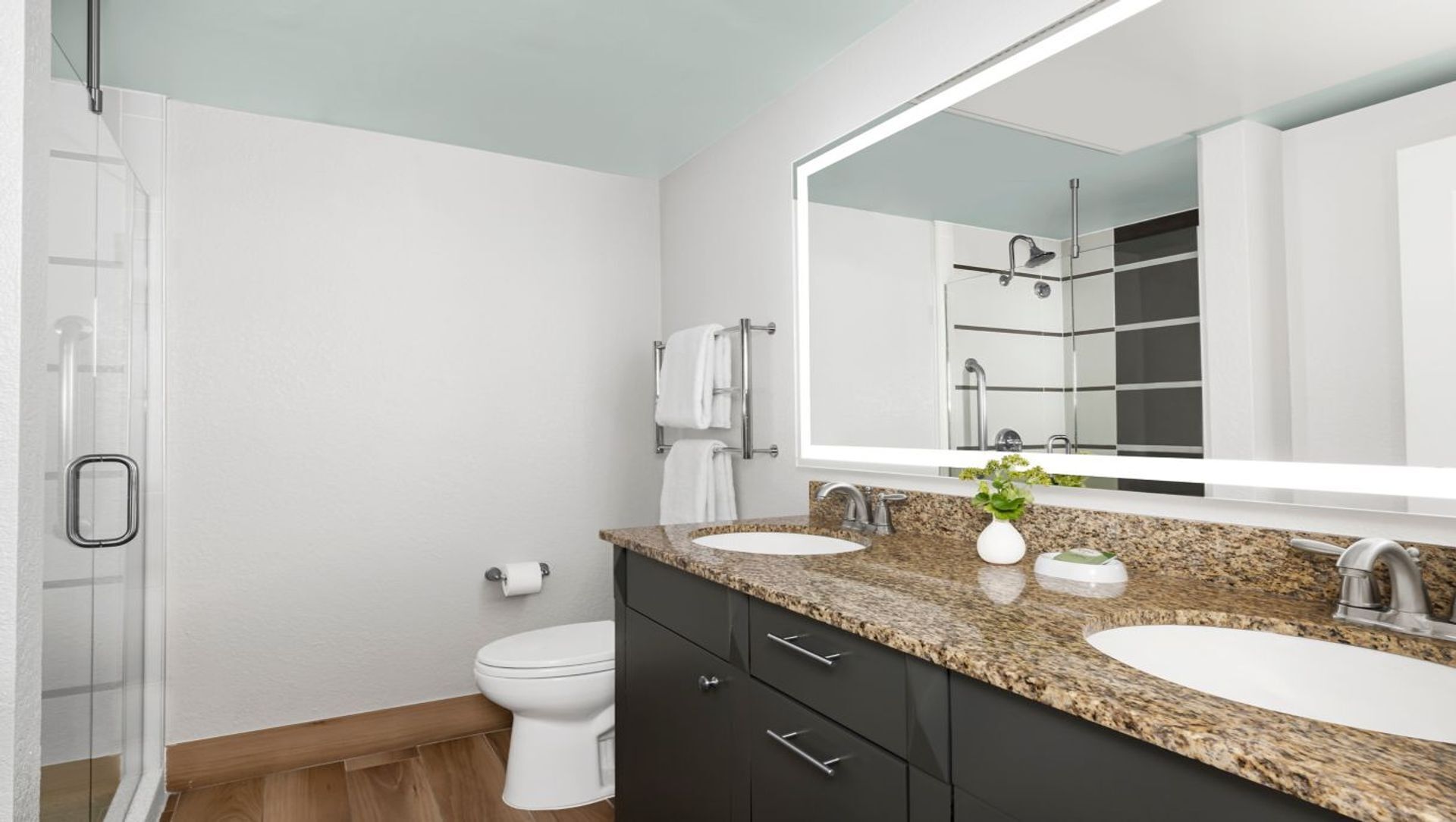 Un baño moderno con dos lavamanos, un inodoro y una ducha.