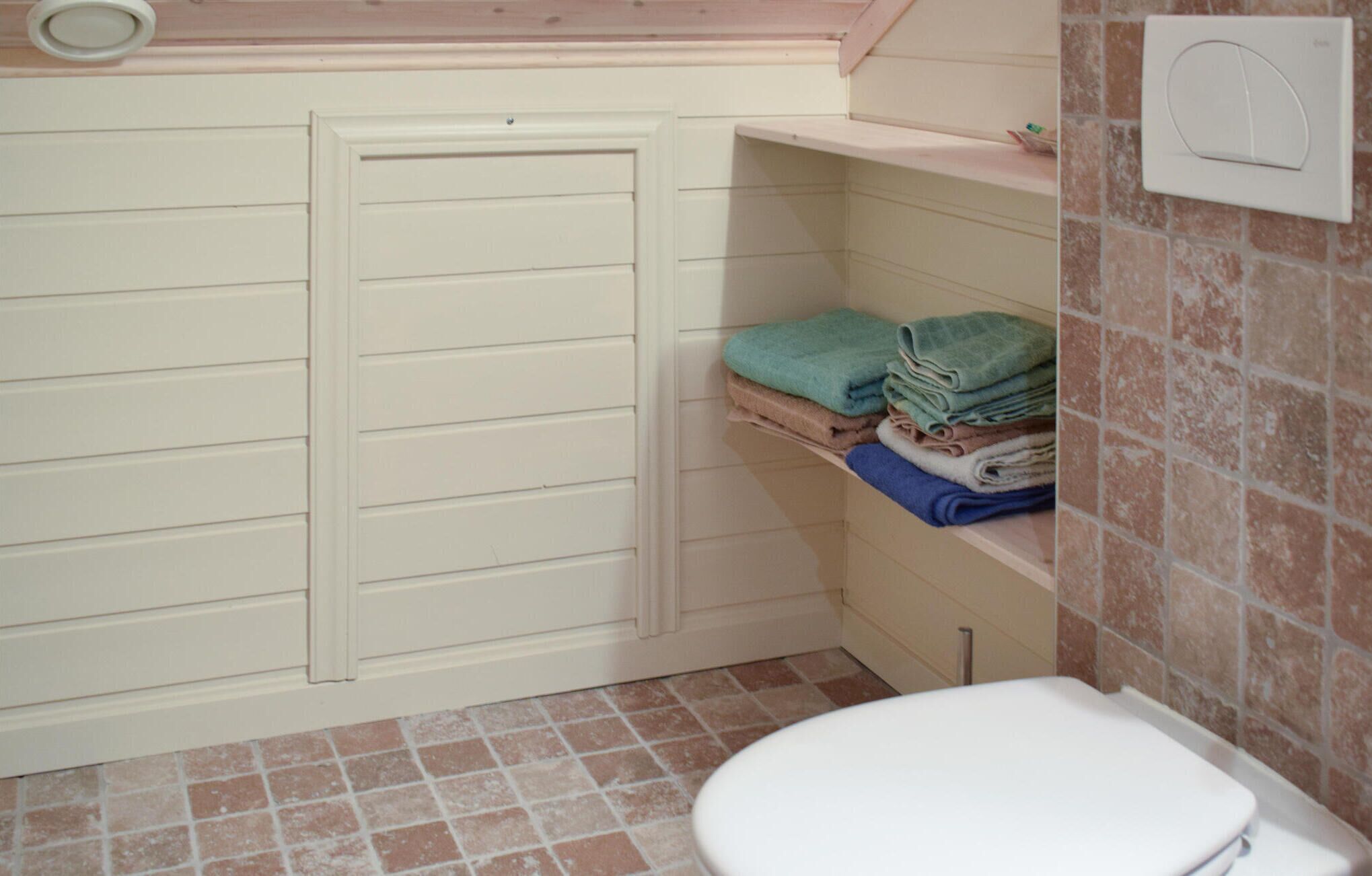 Un baño pequeño con inodoro, toallero y cabina de ducha.