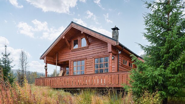 A wooden cabin with a balcony, large windows, and a chimney. - Cozy home in Norheimsund with sauna (Norheimsund)