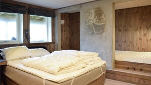 A bedroom with a large bed, a desk, and a window with curtains. - Cozy home in Norheimsund with sauna (Norheimsund)