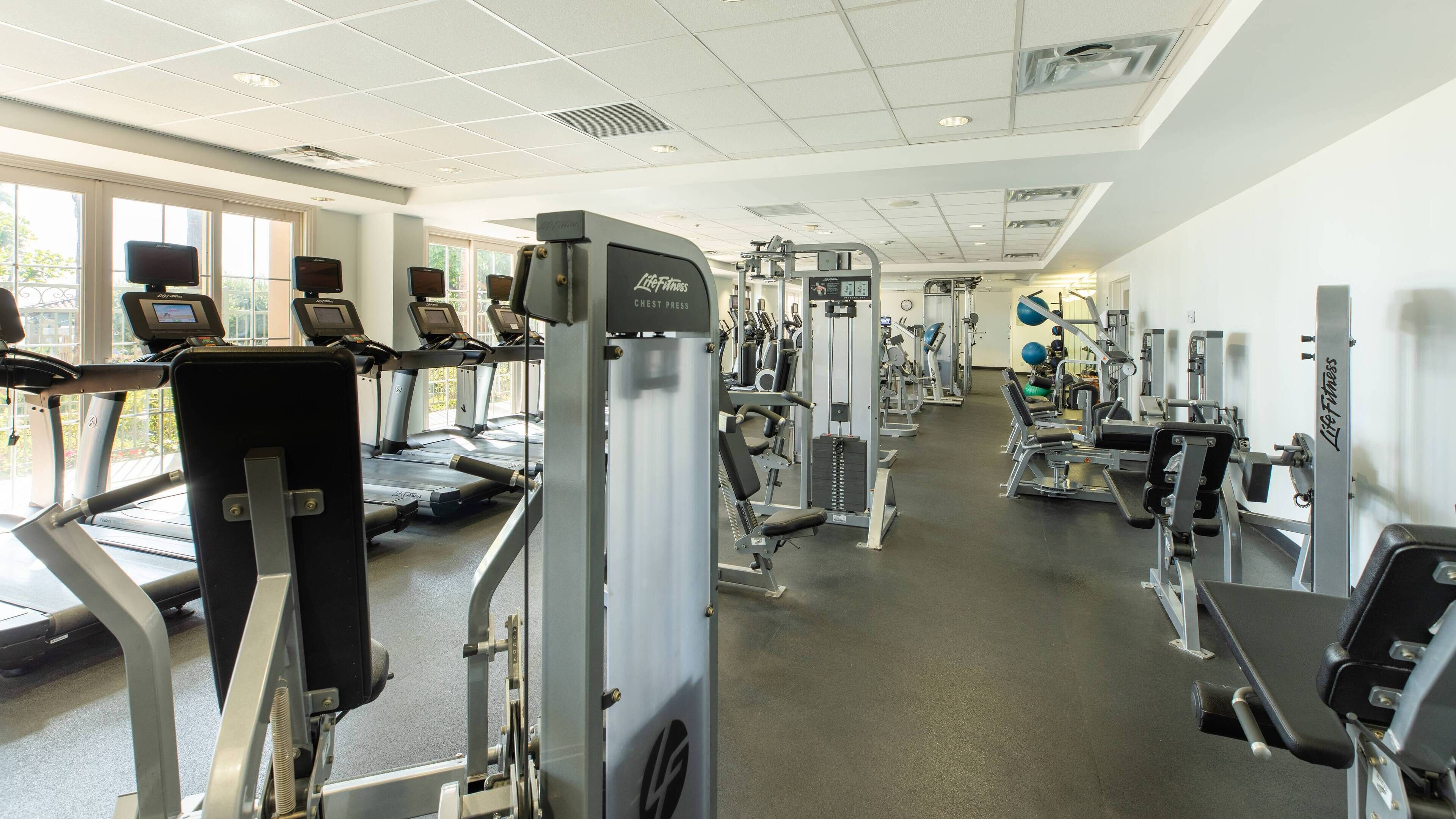 A gym with treadmills, weight machines, and free weights.