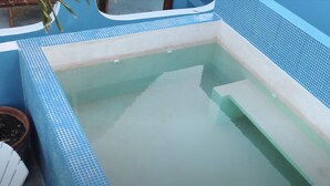 Une petite piscine rectangulaire, bordée de carreaux et dont l’eau est claire.