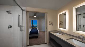 Une salle de bain moderne dotée d’une douche à l’italienne, d’un meuble-lavabo à deux vasques et d’un grand miroir.