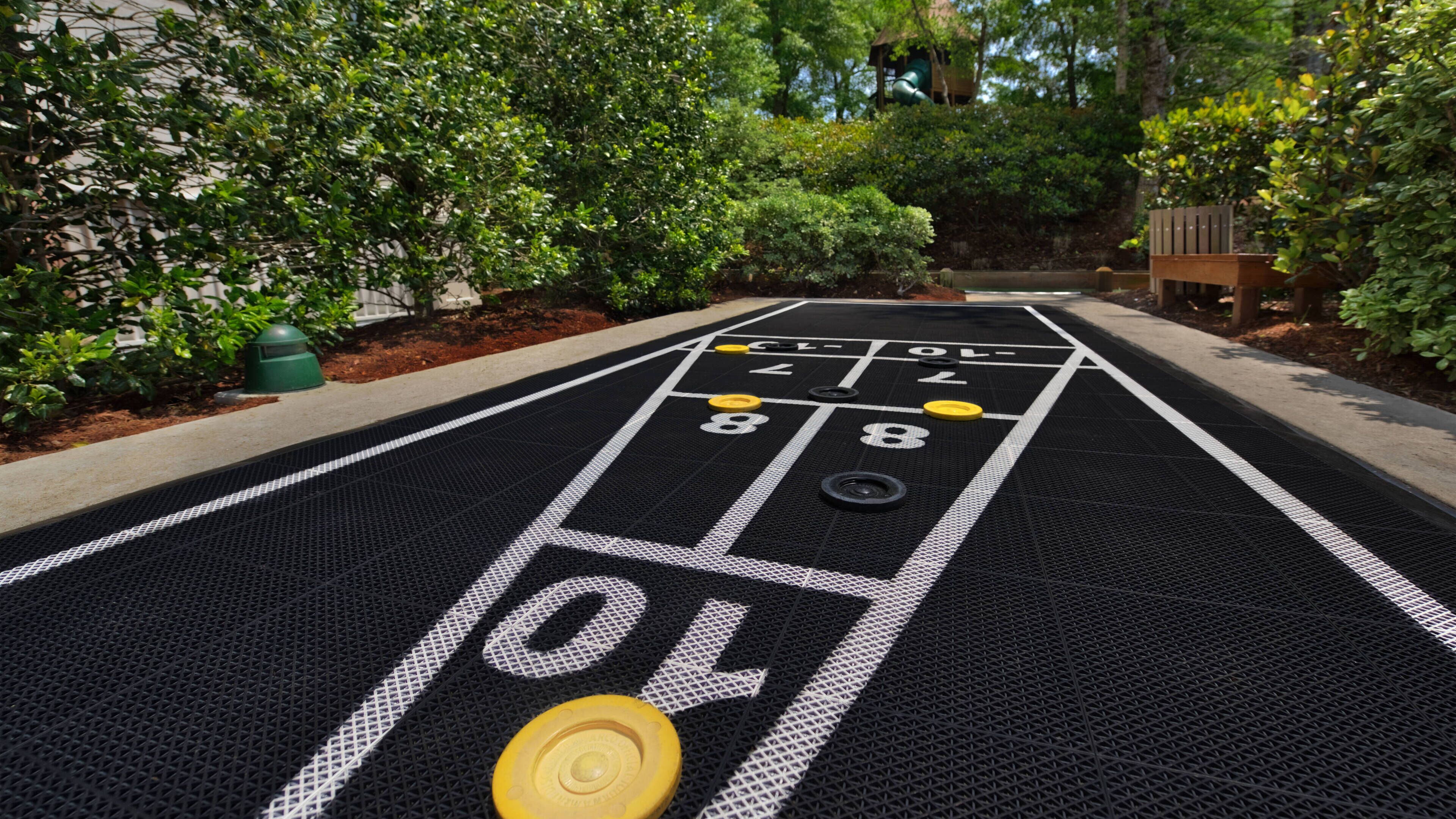 Un tavolo da shuffleboard con aree di punteggio numerate e dischi.