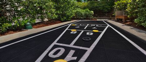 Un tavolo da shuffleboard con aree di punteggio numerate e dischi.