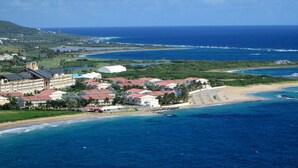 A coastal resort with multiple buildings, a beach, and a view of the ocean.