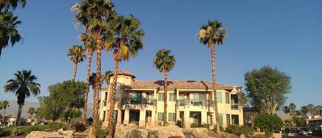 A multi-story building with a Mediterranean architectural style, featuring a flat roof and stucco walls.