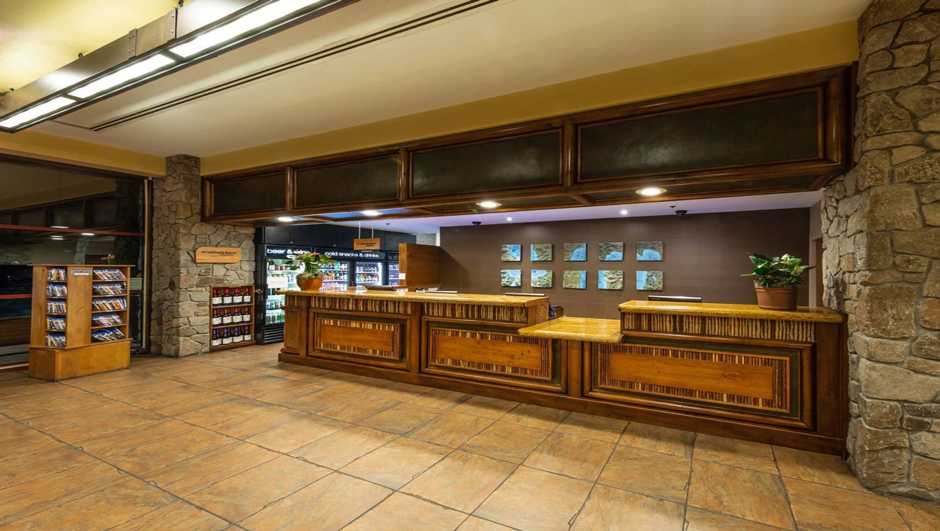 A reception area with a stone wall, wooden reception desk, and a bookshelf.