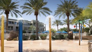 A water feature with multiple jets, palm trees, and a building in the background.